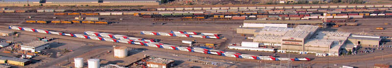 Located towards the right side of the photo is UTA's Warm Springs Service Center where the locomotives and rolling stock for their FrontRunner commuter rail system are maintained. The FrontRunner trains are visible sitting in the yard, as FrontRunner