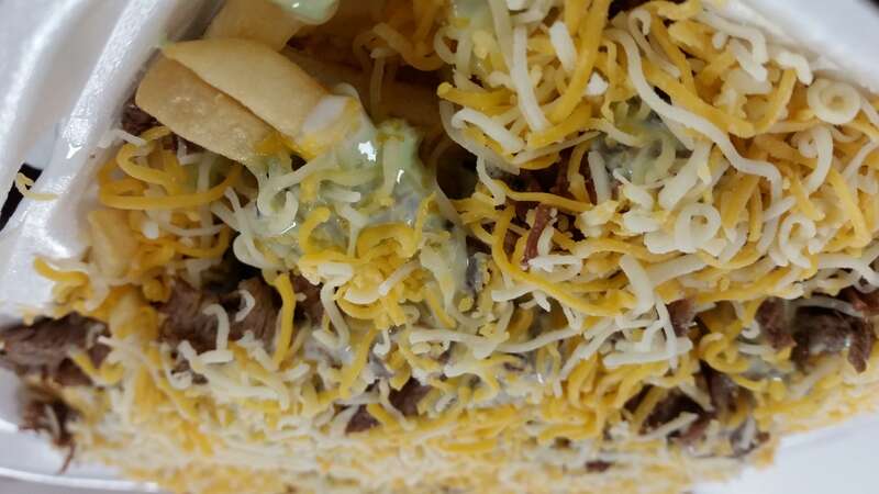 A close up shot of a full size order of Carne Asada Fries made at  Tacos El Gordo on Broadway in Chula Vista, California