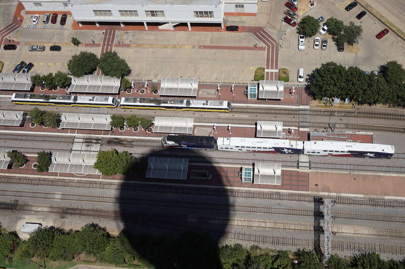 A view of Union Station, with DART Light Rail and Trinity Railway Express trains at the platforms, from the GeO-Deck of Reunion Tower in Dallas, Texas (United States).