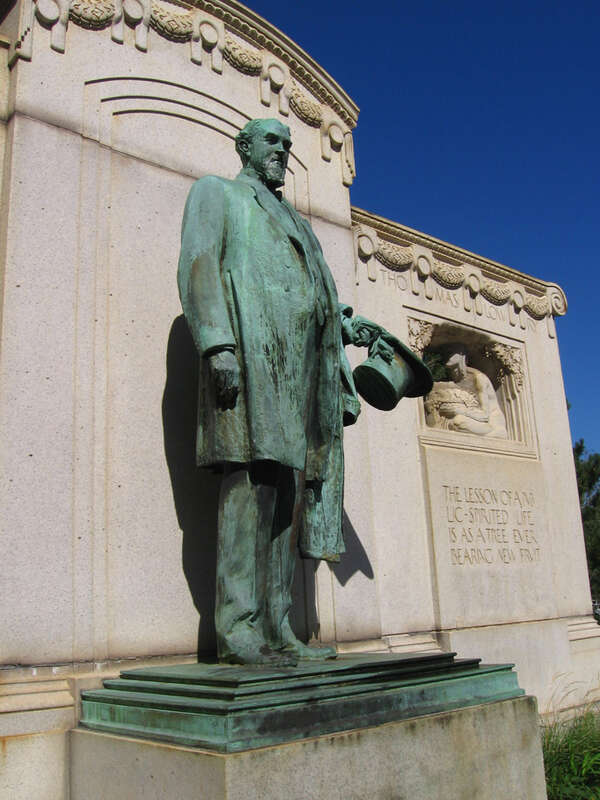 Closeup view of the Thomas Lowry Memorial statue, sculpted by Karl Bitter, in Smith Triangle Park at the intersection of Hennepin Avenue, Emerson Avenue, and 24th Street in Minneapolis, Minnesota. There are two inscriptions, the one on the right side