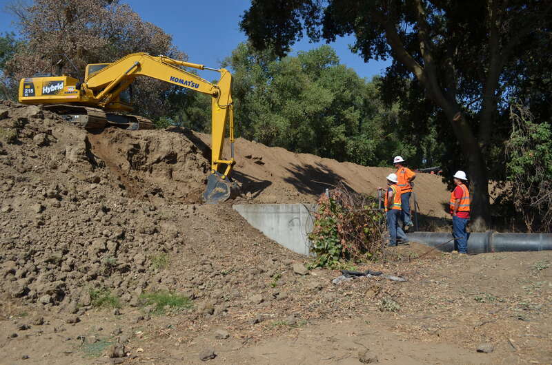 Construction crews for the U.S. Army Corps of Engineers Sacramento District oversee levee work Aug. 21, 2013 along the north bank of the American River in north Sacramento, Calif. Complicating the work are land easement rights, an inactive railroad