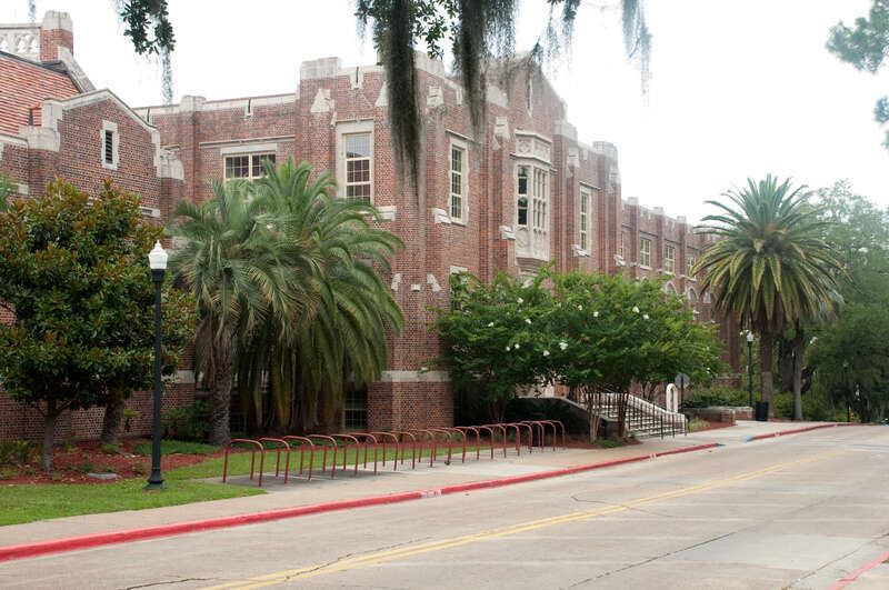 Montgomery Hall, a brick building with Spanish moss and palm tress in front of it on the Florida State University (FSU) campus in Tallahassee, FL