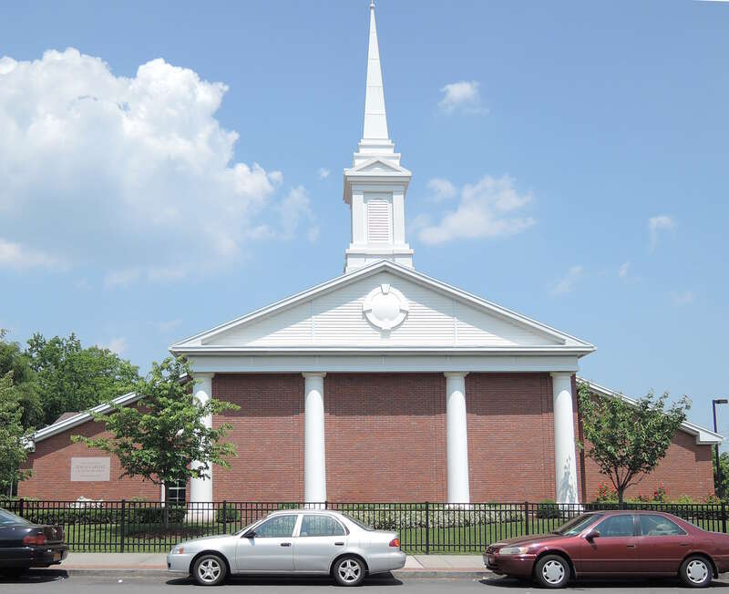 A meetinghouse of The Church of Jesus Christ of Latter-day Saints in New Rochelle, New York. Looking northeast across North Avenue on a sunny hot afternoon.