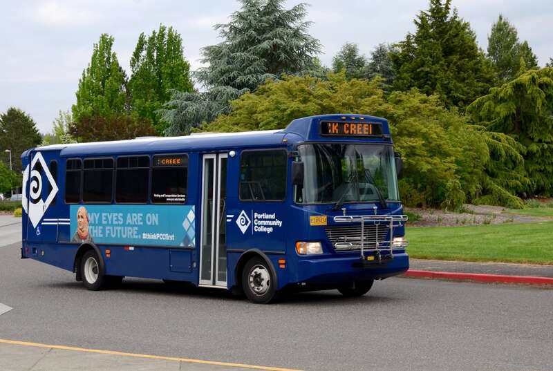 A minibus on the Portland Community College shuttle service, leaving the bus stop on the Rock Creek campus. This particular bus is a Champion CTS Front Engine model.
