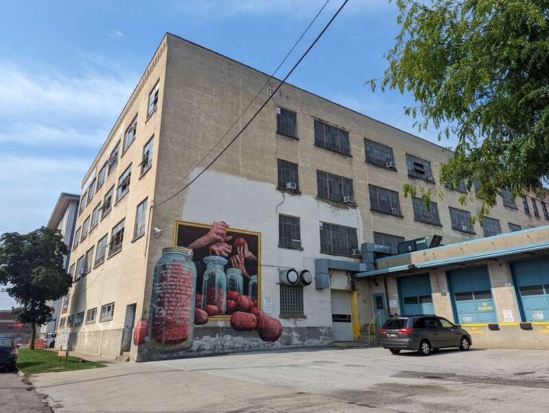 Back of the Park Trades Center, a repurposed building now dedicated to the arts. The mural features the poem &quot;Glass Jars&quot; by Meredith Adams.