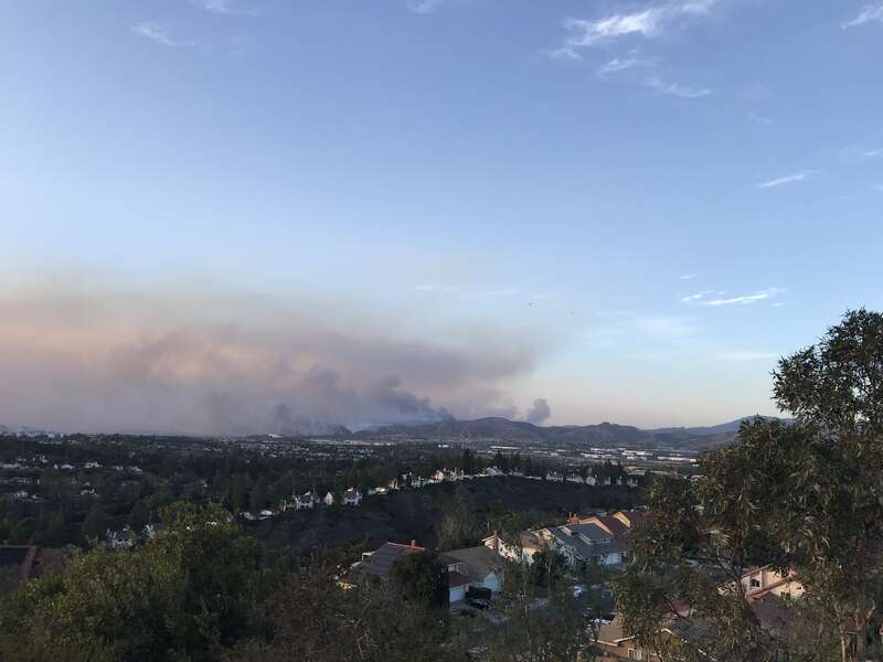 Image of the Silverado Fire roughly 12 hours after it had initially started. Flames can be seen in the image and the smoke is being pushed out towards the ocean due to high Santa Ana Winds. Image was taken along Vista del Largo trail in nearby