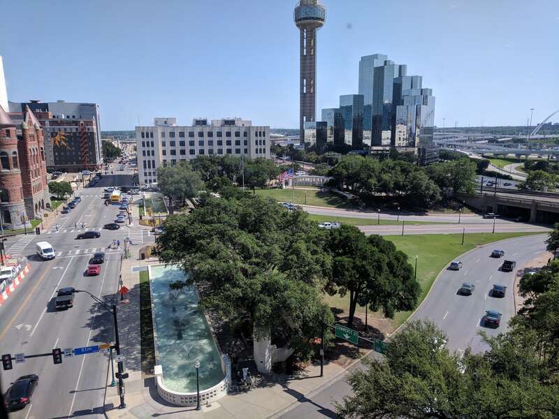 View from the seventh floor. Kennedy's motorcade came towards the camera on Houston (the street on the left), then made a sharp left onto Elm (the curving street on the right) through Dealey Plaza.