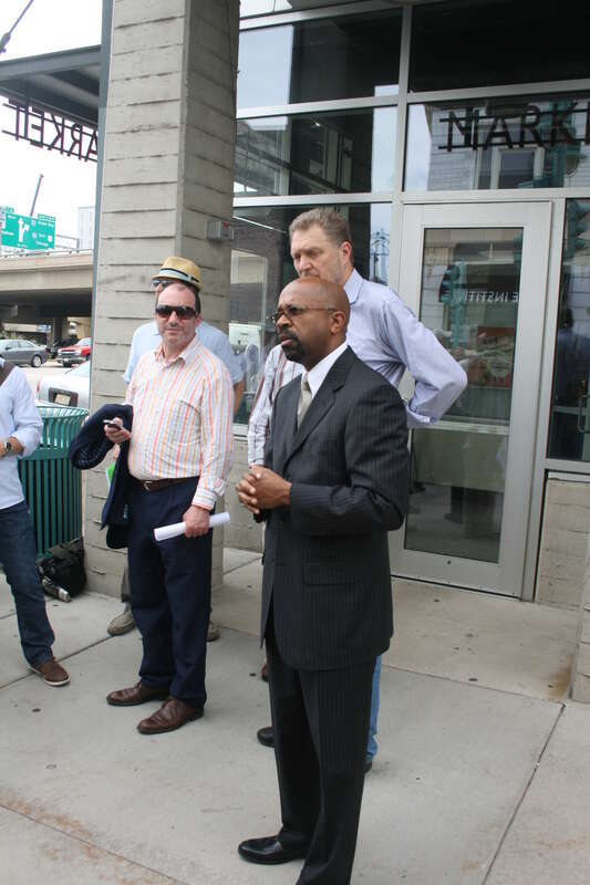 Milwaukee Common Council President Willie Hines speaking in front of the Milwaukee Public Market to Congress for New Urbanism tour participants. John Norquist and Boris Gohkman look on.