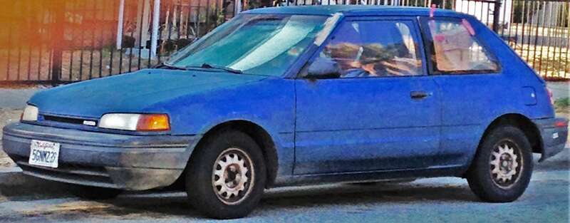 Blue Mazda 323 (3-door Hatchback)
