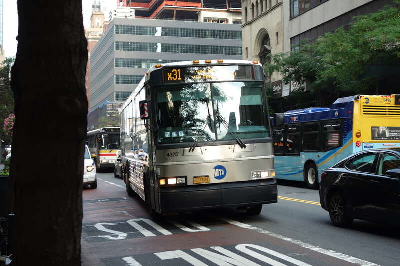 An East Midtown–57th Street-bound X31 express bus traveling east on 34th Street between 8th and 9th Avenues in the Garment District, Midtown Manhattan. The X31 has since been replaced by the SIM31, which no longer travels via the World Financial