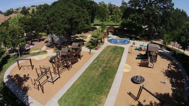Aerial view of Hap Magee Ranch Park showing children's playground in the foreground, picnic area on the left and park area in the background