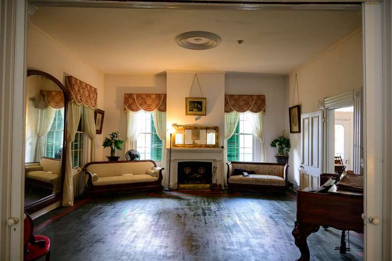 Photograph of the interior of the Bronson-Mulholland House standing in the rear parlor and looking into the front parlor.