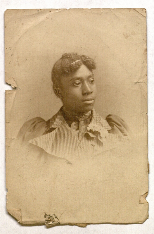Cabinet card photo of a young African American woman in a ruffled dress wearing a corsage. Photo found in New Haven, Connecticut.