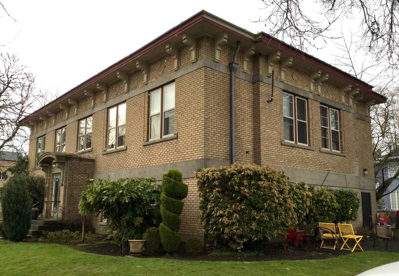 The Old Public Library building, a historic Carnegie library located at 209 NE Lincoln St. in Hillsboro, Oregon, is now occupied by a restaurant on the ground floor and offices above. This view is from the southeast.