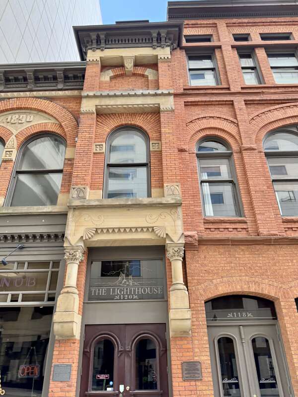 Built in 1890, this Romanesque Revival-style building was designed by Darius B. Moon for the Michigan Millers Mutual Fire Insurance Company.  The building is clad in red brick with limestone trim, a bracketed cornice with modillions and dentils,