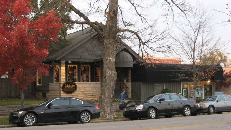 Front and western side of the Melody Music Shop, located at 402 W. Sixth Street in Bloomington, Indiana, United States.  Built in 1950, it is part of the Bloomington West Side Historic District, a historic district that is listed on the National