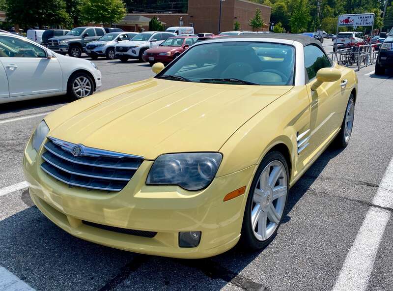 2005 Chrysler Crossfire roadster finished in yellow with black fabric top. Photographed September 2024 in Bowie, Maryland.