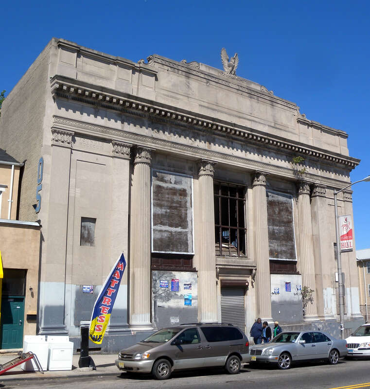 Looking northeast across Clinton Avenue at Clinton Trust bank building on a sunny midday.