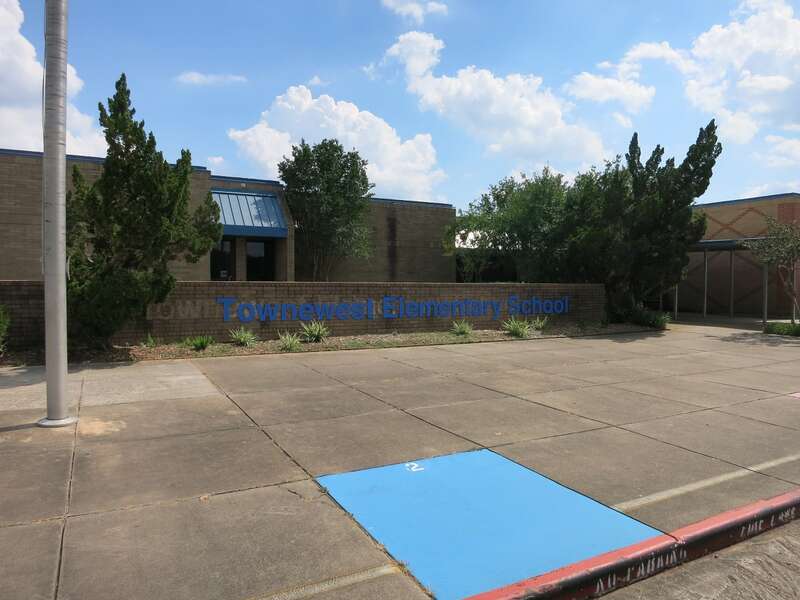 Photo shows Towne West Elementary School at 13927 Old Richmond Rd, (Sugar Land, TX address) 77498, in an unincorporated area. It is part of the Fort Bend Independent School District. View is toward the south.