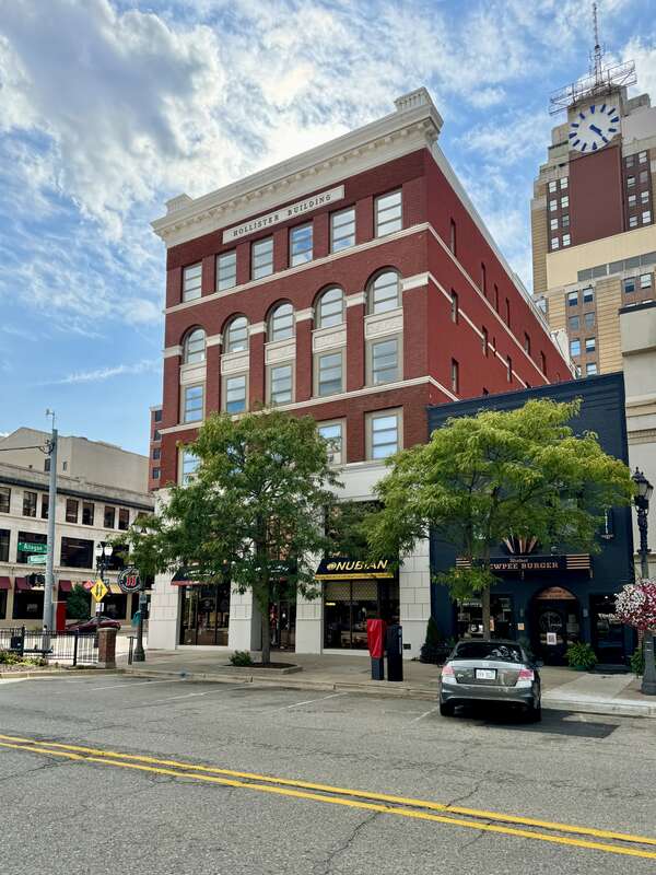 Built in 1890-1893, this First Renaissance Revival-style building is clad in red brick with stone trim, a cornice with modillions and dentils, replacement windows, a modified first floor facade, and arched window bays on the third and fourth floors.