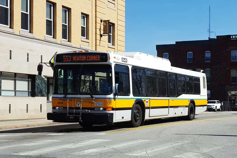A Newton Corner-bound MBTA route 553 bus in Central Square, Waltham, in April 2016