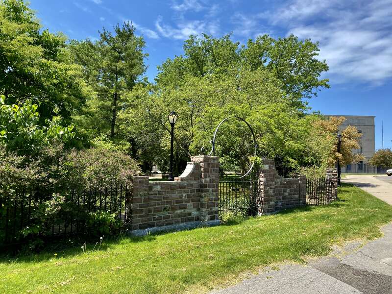 As seen in May 2021: the imposing stone fencing surrounding the "cottage garden" at Martin Luther King, Jr. Park, designed by pioneering African-American architect John Brent. Tucked away inconspicuously behind the Science Museum, facing the parking