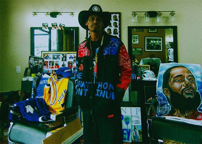 This photograph is part of the ongoing visual series 'Nipsey Hussle: The Marathon Continues' by Oscar Reyes Chavez, documenting individuals, spaces, and cultural symbols connected to Nipsey Hussle’s legacy. The subject is shown in a customized outfit