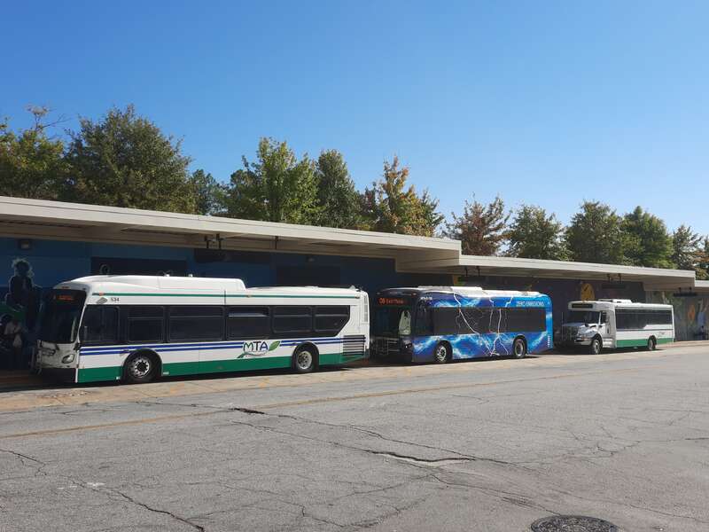 Three different types of transit busses at the Macon, Ga Terminal Station transit hub. A full-size buss on the left, an electric buss in the middle, and a smaller buss on the right.