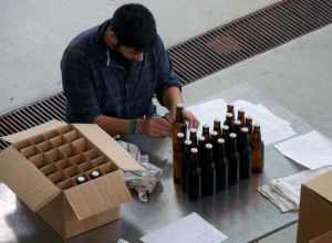 A person labeling experimental beer at the fermentation lab at Oregon State University