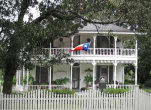 Thomas Jackson and Mary Lelia (Sherman) Dick lived on their north Galveston County "Buckhorn Ranch" for many years before hiring J. R. Beerwort and O. V. King to build this house in 1904. It is a good example of a two-story center passage plan with a