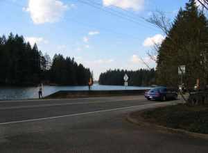 Children fish while standing on the SR 500 bridge over the intersection of Lacamas Lake and Round Lake in Washington. The camera was positioned in the parking lot of Lacamas Park and was facing west.