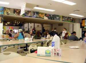 A light crowd sitting at the Long Beach City College (Liberal Arts Campus) cafeteria while a live jazz band performs on stage.The photograph was taken with a Nikon Coolpix e3200 digital camera and edited (for brightness, contrast, color balance and