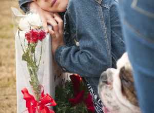 Abby Mattox, 6, hugs her grandfather's headstone at the Central Texas State Veterans Cemetery after placing a Christmas wreath on it, Nov. 30, 2013. More than 1,000 volunteers from the Fort Hood/Killeen area joined family members of the fallen to