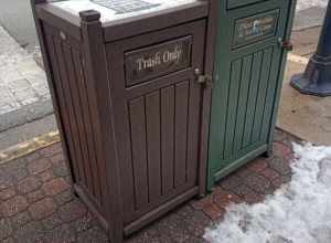 Gray plastic waste container divided between "trash only" and "plastic bottles and metal cans" in downtown Springfield, Illinois.