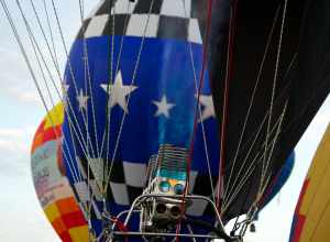 A balloon pilot warms his balloon for lift-off. Albuquerque International Balloon Fiesta, 2012. Over 750 ballons on site.