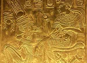 Scene from the golden shrine of Tutankhamun. King and Queen are seated and Tutankhamun seems to pour ointment on Queen's hand.