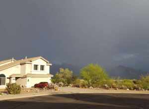 A photo of a house in Oro Valley, Arizona, with a rain storm going on behind it, in July 2022.