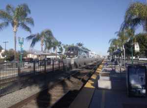 Metrolink station in Covina from the east end of the platform looking west. A train is arriving headed east towards Downtown LA.