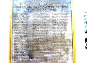 Looking southeast at honor role plaque for The World War on a sunny morning.