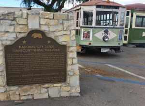 A plaque for California Registered Historical Landmark No. 1023 as well as some modified trolley cars