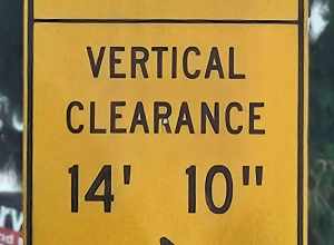 Traffic sign indicating an upcoming bridge has an underside clearance of 14 feet 10 inches (4.52 m).