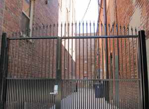 Photo of a gated alley in Lincoln, Nebraska.  This alley is the first east of N. 14th on the south side of "P" Streets.  Photo is taken looking south from the south sidewalk on "P".