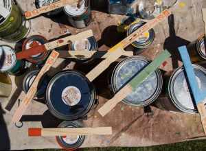 Brushes, stirrers and paint cans sit ready for use at a mural painting at Perkins Elementary School.